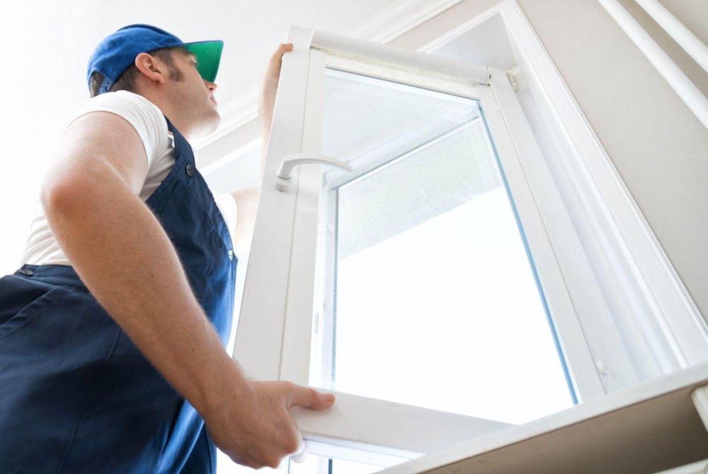 Professional installer replacing a vinyl window during a full home window replacement project in Calgary.