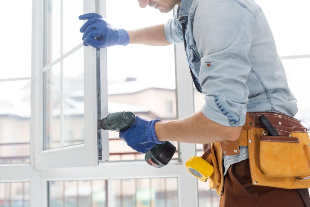 A professional inspecting and repairing a vinyl window to determine whether repair or full replacement is needed.
